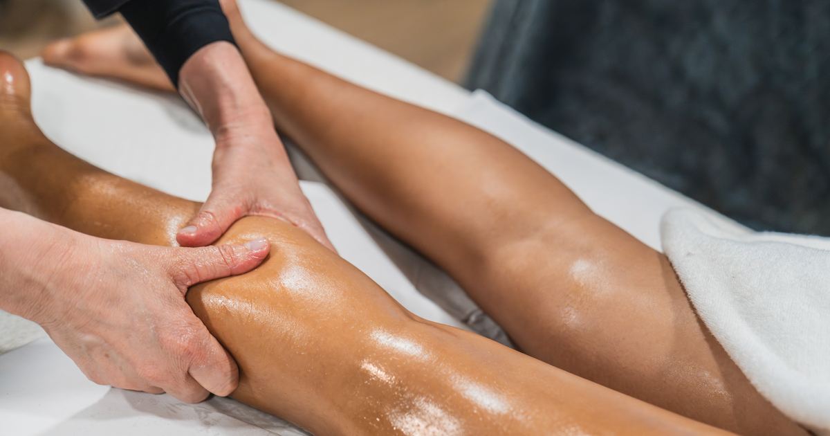 Manuelle Lymphdrainage (MLD) als Hausbesuch in München – Physiotherapie Köpple Physiotherapeutin führt eine manuelle Lymphdrainage am Bein einer Patientin durch